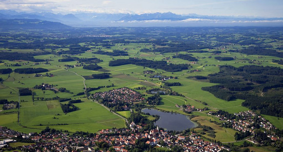 Luftaufnahme vom Allgäu: Kleine Stadt am See mit Feldern und Wiesen